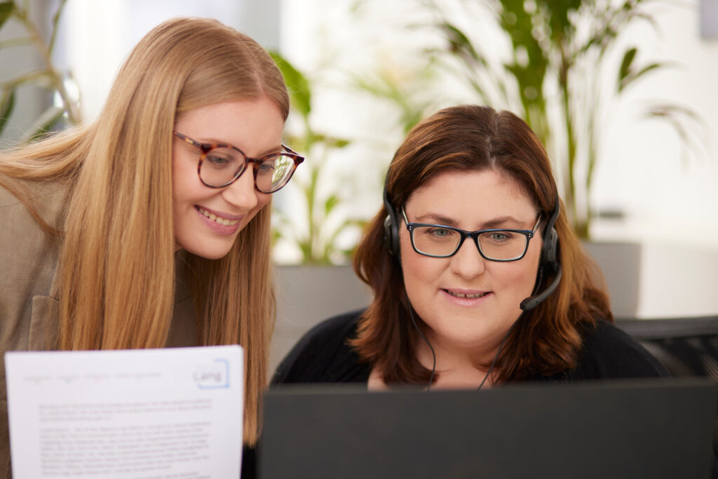 Unsere Mitarbeiterinnen besprechen vor dem Bildschirm, wie sie die Website-Übersetzungen am gezieltesten durchführen.