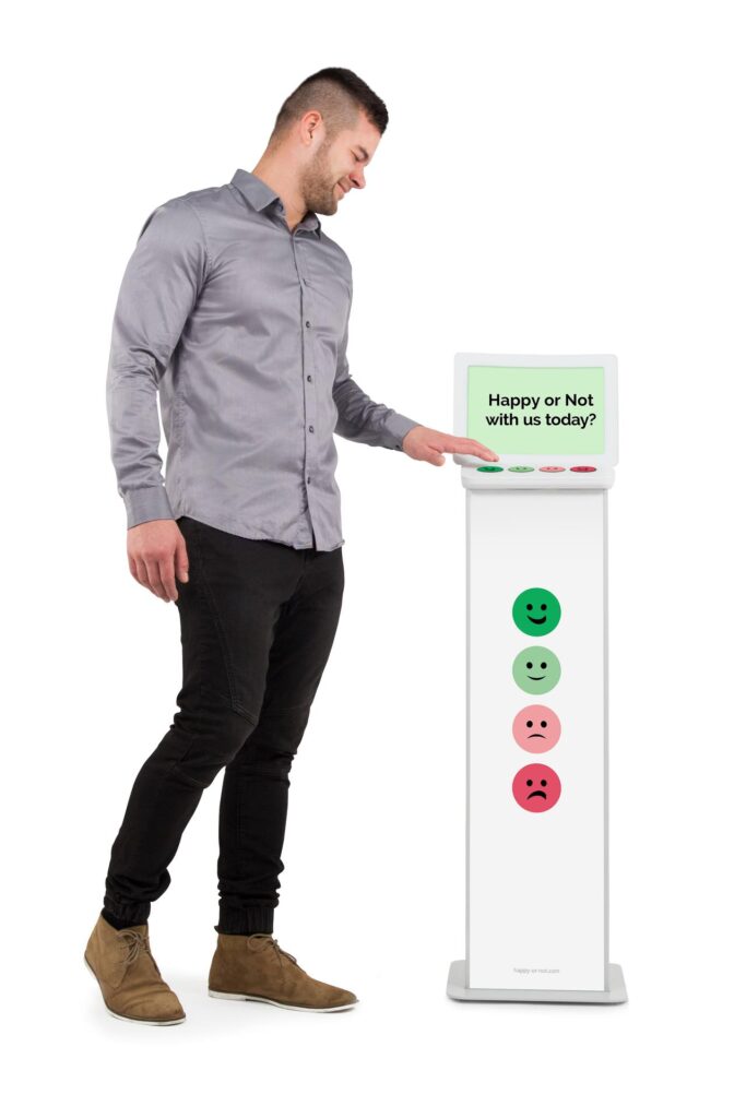 Eine männliche Person betätigt den dunkelgrünen Knopf eines Feedback-Buzzers.