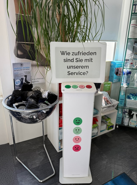 Ein Buttons-Aufsteller mit dem Frageschildhalter bei einem Sanitätshändler in Eisenstadt. Die Umfrage lautet: "Wie zufrieden sind Sie mit unserem Service?"